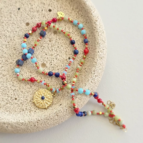 Unikatowy naszyjnik supełkowany z lapis lazuli, koralu, amazonitu, jadeitu i hematytu na czerwonym sznurku z zawieszką słońce i oko – biżuteria z naturalnych kamieni. Magneska.pl