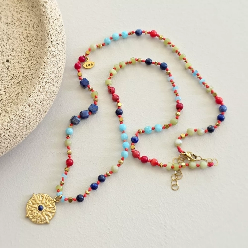 Unikatowy naszyjnik supełkowany z lapis lazuli, koralu, amazonitu, jadeitu i hematytu na czerwonym sznurku z zawieszką słońce i oko – biżuteria z naturalnych kamieni. Magneska.pl