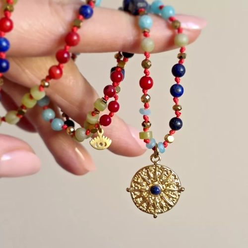 Unikatowy naszyjnik supełkowany z lapis lazuli, koralu, amazonitu, jadeitu i hematytu na czerwonym sznurku z zawieszką słońce i oko – biżuteria z naturalnych kamieni. Magneska.pl