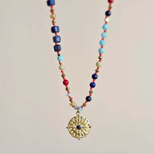 Unikatowy naszyjnik supełkowany z lapis lazuli, koralu, amazonitu, jadeitu i hematytu na czerwonym sznurku z zawieszką słońce i oko – biżuteria z naturalnych kamieni. Magneska.pl