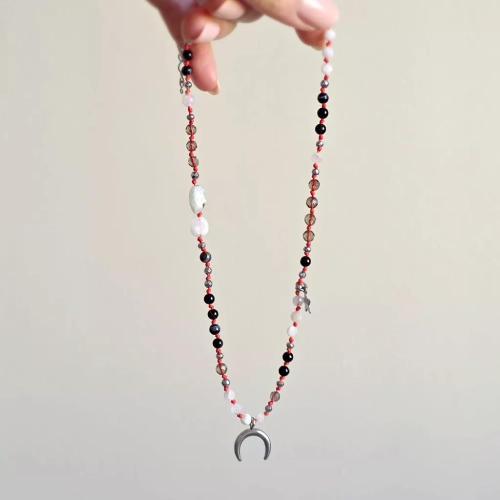 Unikatowy naszyjnik supełkowany z czarnego agatu, kamienia księżycowego, kwarcu dymnego i hematytu na czerwonym sznurku z zawieszką lunula – biżuteria z naturalnych kamieni Magneska.pl