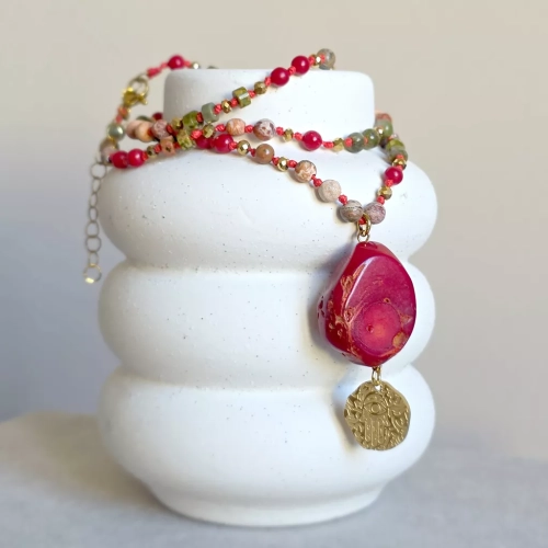 Unikatowy naszyjnik supełkowany z koralu, unakitu, jaspisu leopardziego i złotego hematytu na czerwonym sznurku z medalionem hamsa zawieszonym pod dużym plastrem korala – biżuteria z naturalnych kamieni Magneska.pl