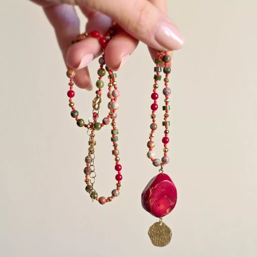 Unikatowy naszyjnik supełkowany z koralu, unakitu, jaspisu leopardziego i złotego hematytu na czerwonym sznurku z medalionem hamsa zawieszonym pod dużym plastrem korala – biżuteria z naturalnych kamieni Magneska.pl