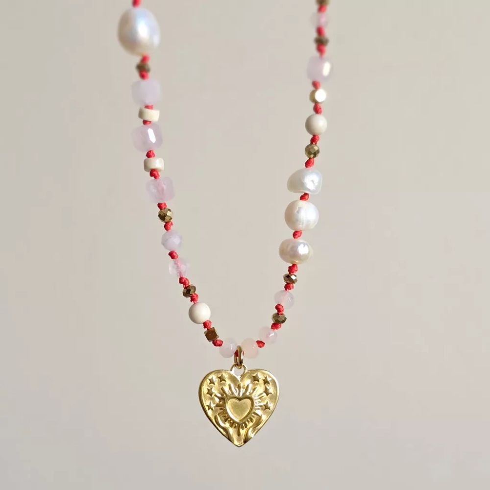 Unikatowy naszyjnik supełkowany z kwarcu różowego, agatu, perły, kamienia rzecznego i złotego hematytu na czerwonym sznurku z zawieszką serce z tłoczeniem dłoni unoszących promieniste serce – biżuteria Magneska.pl.