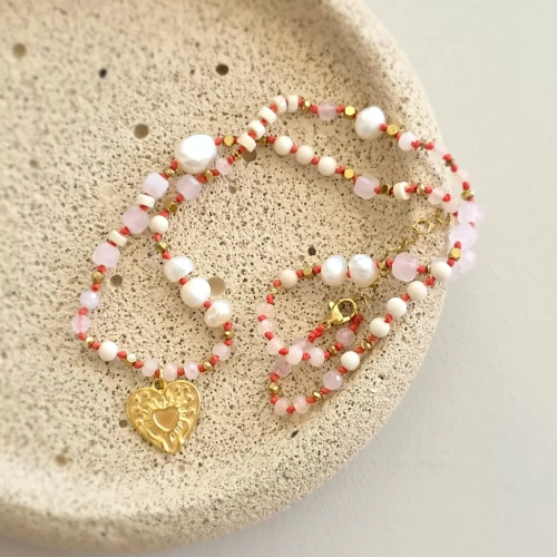 Unikatowy naszyjnik supełkowany z kwarcu różowego, agatu, perły, kamienia rzecznego i złotego hematytu na czerwonym sznurku z zawieszką serce z tłoczeniem dłoni unoszących promieniste serce – biżuteria Magneska.pl.