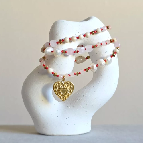 Unikatowy naszyjnik supełkowany z kwarcu różowego, agatu, perły, kamienia rzecznego i złotego hematytu na czerwonym sznurku z zawieszką serce z tłoczeniem dłoni unoszących promieniste serce – biżuteria Magneska.pl.
