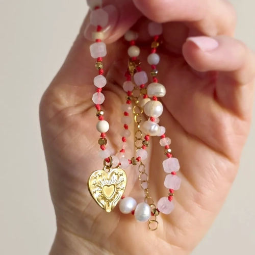 Unikatowy naszyjnik supełkowany z kwarcu różowego, agatu, perły, kamienia rzecznego i złotego hematytu na czerwonym sznurku z zawieszką serce z tłoczeniem dłoni unoszących promieniste serce – biżuteria Magneska.pl.