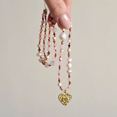 Unikatowy naszyjnik supełkowany z kwarcu różowego, agatu, perły, kamienia rzecznego i złotego hematytu na czerwonym sznurku z zawieszką serce z tłoczeniem dłoni unoszących promieniste serce – biżuteria Magneska.pl.