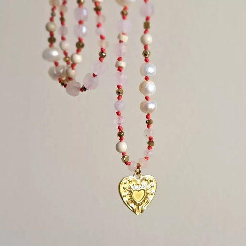 Unikatowy naszyjnik supełkowany z kwarcu różowego, agatu, perły, kamienia rzecznego i złotego hematytu na czerwonym sznurku z zawieszką serce z tłoczeniem dłoni unoszących promieniste serce – biżuteria Magneska.pl.