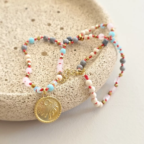 Unikatowy naszyjnik supełkowany z kwarcu różowego, amazonitu, kamienia rzecznego, jaspisu szarego i złotego hematytu na czerwonym sznurku z medalionem słońce – biżuteria z naturalnych kamieni Magneska.pl