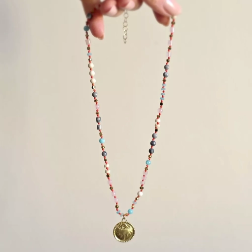 Unikatowy naszyjnik supełkowany z kwarcu różowego, amazonitu, kamienia rzecznego, jaspisu szarego i złotego hematytu na czerwonym sznurku z medalionem słońce – biżuteria z naturalnych kamieni Magneska.pl