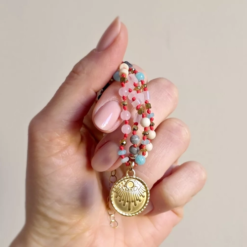 Unikatowy naszyjnik supełkowany z kwarcu różowego, amazonitu, kamienia rzecznego, jaspisu szarego i złotego hematytu na czerwonym sznurku z medalionem słońce – biżuteria z naturalnych kamieni Magneska.pl