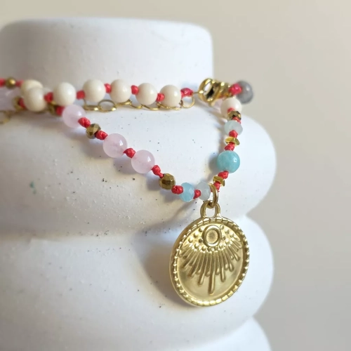 Unikatowy naszyjnik supełkowany z kwarcu różowego, amazonitu, kamienia rzecznego, jaspisu szarego i złotego hematytu na czerwonym sznurku z medalionem słońce – biżuteria z naturalnych kamieni Magneska.pl