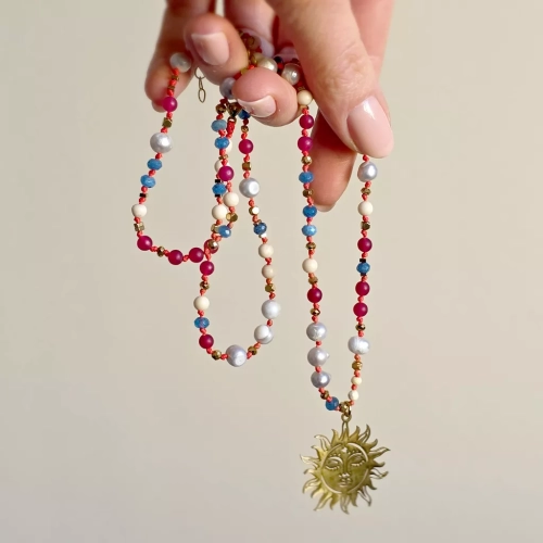 Unikatowy naszyjnik supełkowany z kamienia rzecznego, agatu, jadeitu, szarych pereł i złotego hematytu na czerwonym sznurku z zawieszką słońce – biżuteria z naturalnych kamieni Magneska.pl