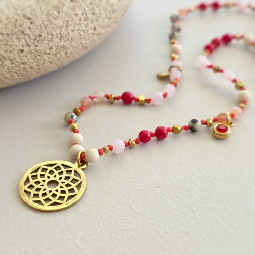 Unikatowy naszyjnik supełkowany z jaspisu dalmatyńskiego, koralu, kwarcu różowego, kamienia rzecznego i złotego hematytu na czerwonym sznurku z ażurową mandalą, zawieszką z czerwonym oczkiem i blaszką Magneska – biżuteria z naturalnych kamieni Magneska.pl