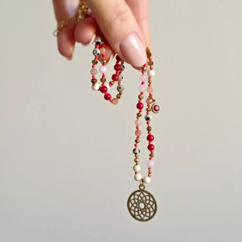 Unikatowy naszyjnik supełkowany z jaspisu dalmatyńskiego, koralu, kwarcu różowego, kamienia rzecznego i złotego hematytu na czerwonym sznurku z ażurową mandalą, zawieszką z czerwonym oczkiem i blaszką Magneska – biżuteria z naturalnych kamieni Magneska.pl