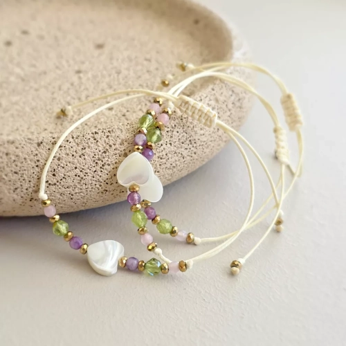 Bransoletka z masą perłową w kształcie serca, kolorowymi agatami, peridotem i złotym hematytem na kremowym sznurku – ręcznie tworzona biżuteria Magneska.pl.