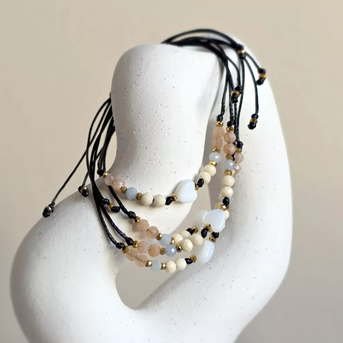 Bransoletka z serduszkiem z masy perłowej. Delikatne kamienie na cienkim, czarnym sznurku. Bransoletka z angelitem, kamieniem słonecznym i kamieniem rzecznym, delikatność na każdy dzień. Magneska.pl