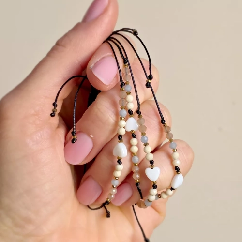 Bransoletka z serduszkiem z masy perłowej. Delikatne kamienie na cienkim, czarnym sznurku. Bransoletka z angelitem, kamieniem słonecznym i kamieniem rzecznym, delikatność na każdy dzień. Magneska.pl