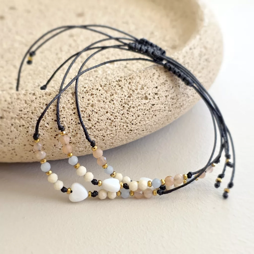 Bransoletka z serduszkiem z masy perłowej. Delikatne kamienie na cienkim, czarnym sznurku. Bransoletka z angelitem, kamieniem słonecznym i kamieniem rzecznym, delikatność na każdy dzień. Magneska.pl