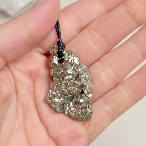 Unikatowy naszyjnik z surową bryłką pirytu o metalicznym połysku na regulowanym czarnym sznurku – ręcznie tworzona biżuteria magneska.pl